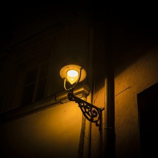 Lampadaire allumé dans une rue sombre