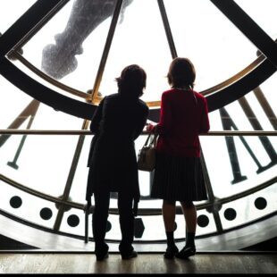 Deux enfants de dos devant l'horloge au musée d'Orsay.