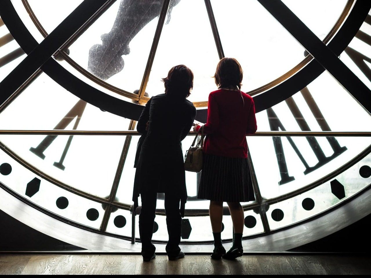Deux enfants de dos devant l'horloge au musée d'Orsay.