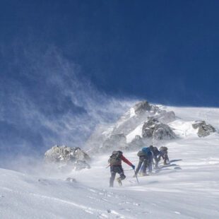 Alpinistes près d'un sommet enneigé sur fond de ciel bleu