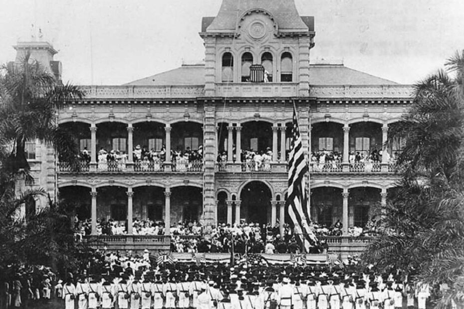 Levée du drapeau américain lors de la cérémonie d'annexion des États-Unis au Palais ʻIolani, à Honolulu, Hawaï. Les marines américains qui participent à la cérémonie appartiennent à l'USS Philadelphia. Collection : Collection Ray Jerome Baker.