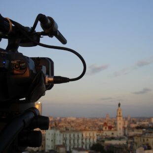 Vue de côté d'une caméra qui filme une ville au loin.