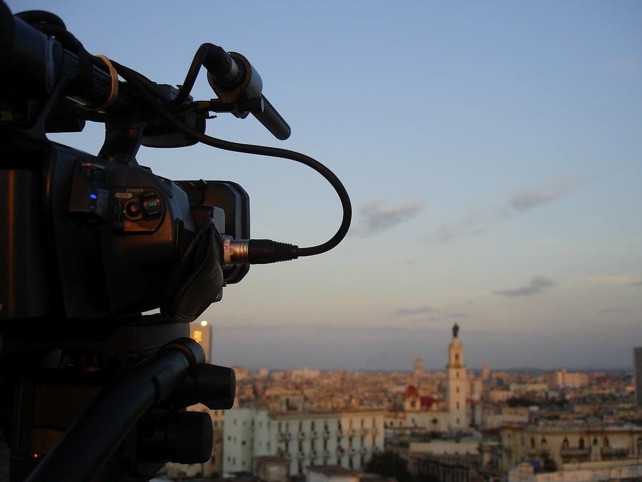 Vue de côté d'une caméra qui filme une ville au loin.