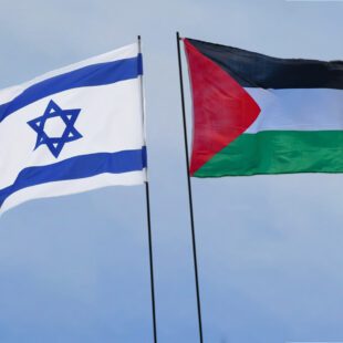 Drapeaux au vent d'Israel et de la Palestine dos à dos sur fond de ciel bleu