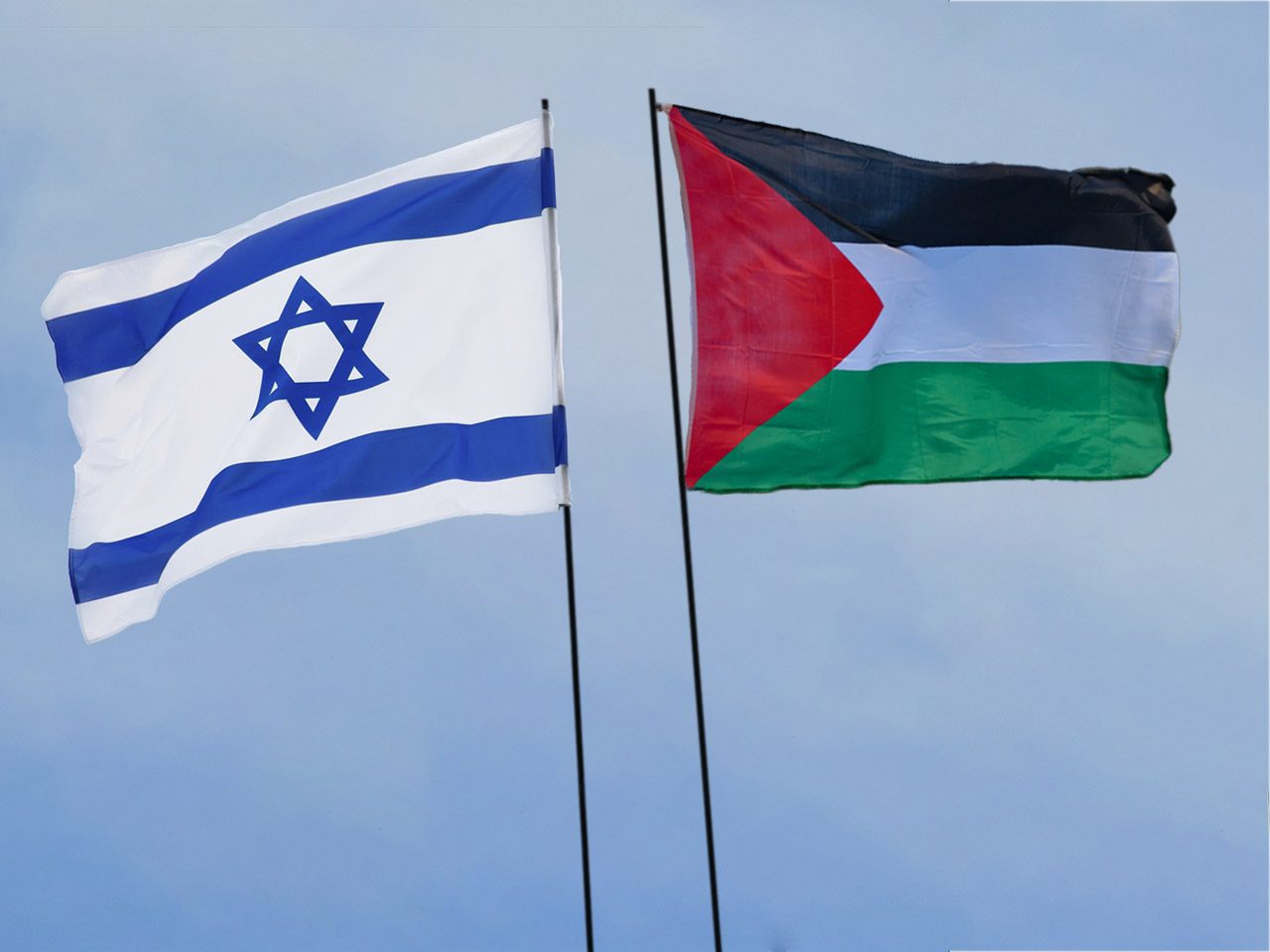 Drapeaux au vent d'Israel et de la Palestine dos à dos sur fond de ciel bleu