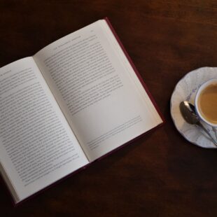 Livre ouvert sur une table à côté d'une tasse de café.