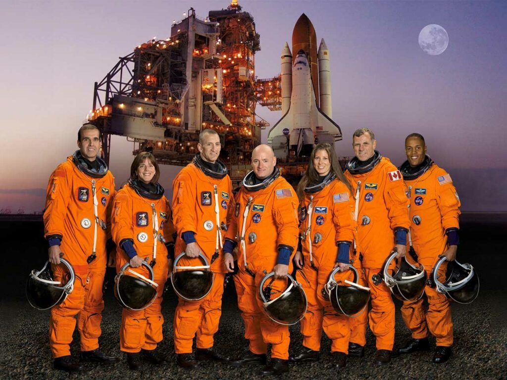 Equipe de 7 astronautes vêtus de leurs combinaisons de lancement et d'entrée dans la navette