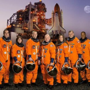 Equipe de 7 astronautes vêtus de leurs combinaisons de lancement et d'entrée dans la navette