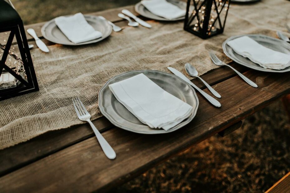 Assiettes et couverts sur table en bois et nappe