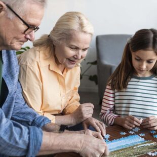 Personnes agées faisant un puzzle avec une petite fille