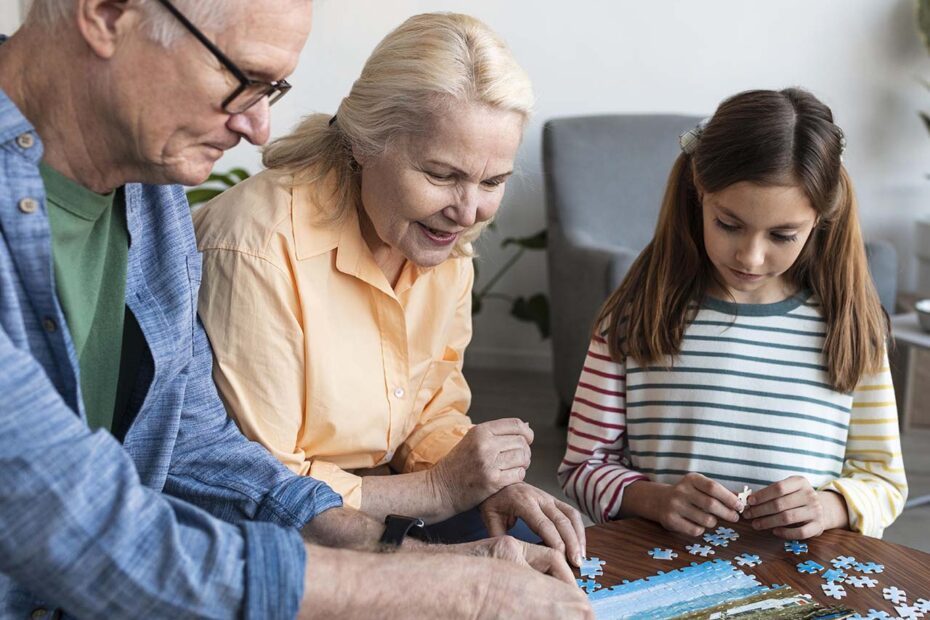 Personnes agées faisant un puzzle avec une petite fille