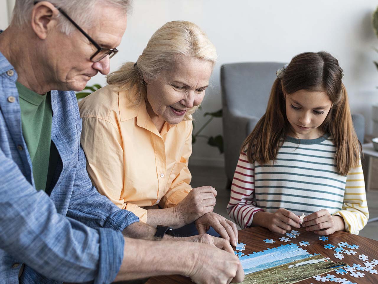 Personnes agées faisant un puzzle avec une petite fille