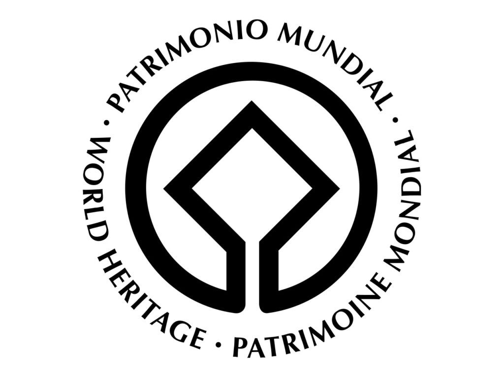 Logo en noir et blanc et en format paysage. Le carré du logo représente le patrimoine bâti créé par l'homme. Il est entouré par un cercle qui symbolise le globe terrestre évoquant le patrimoine naturel.