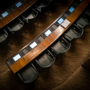 Photo illustrant les tables avec micro et siège des députés au Parlement.